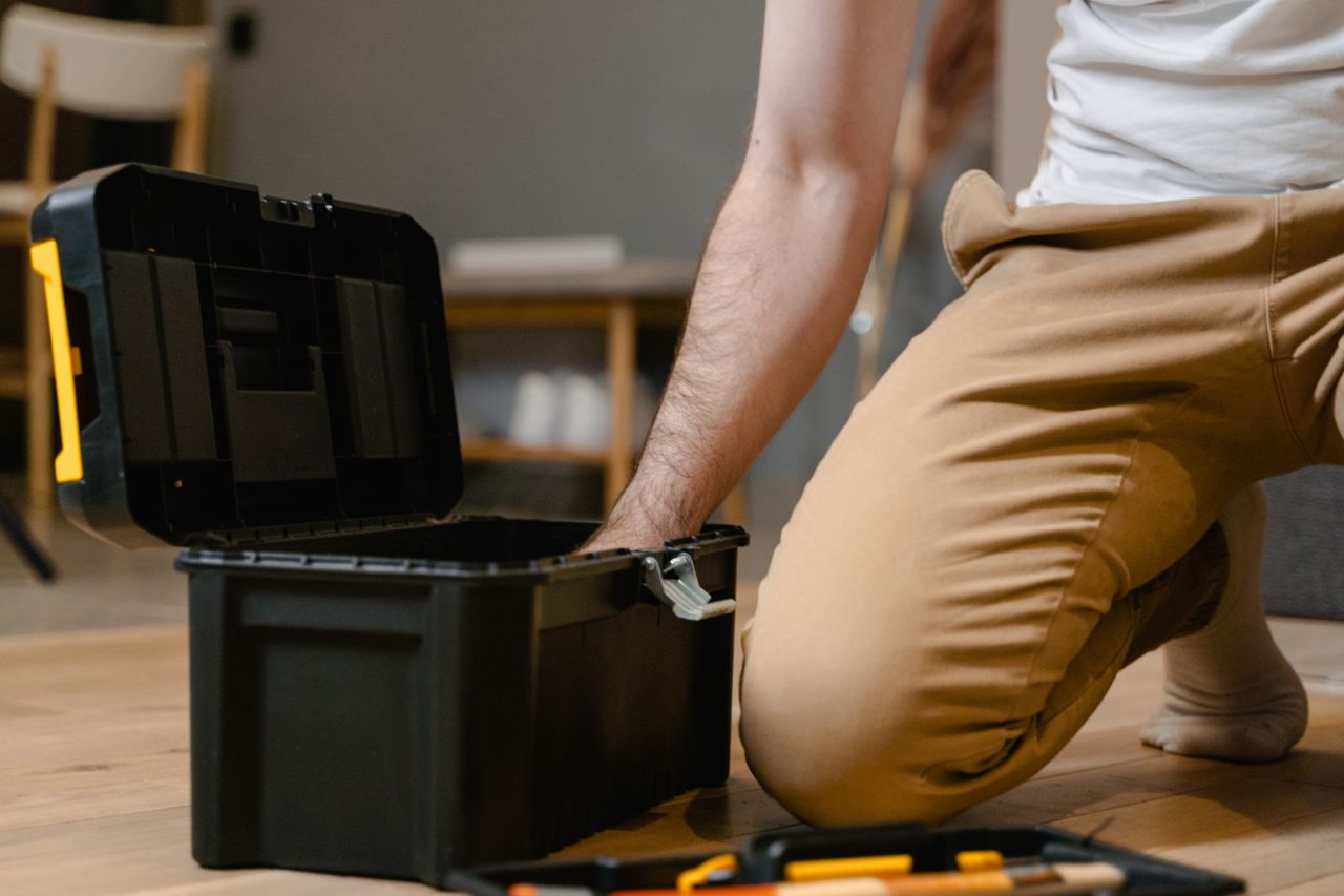 why-choose-us-02 A man opening a tool box indoors, preparing for home repair.